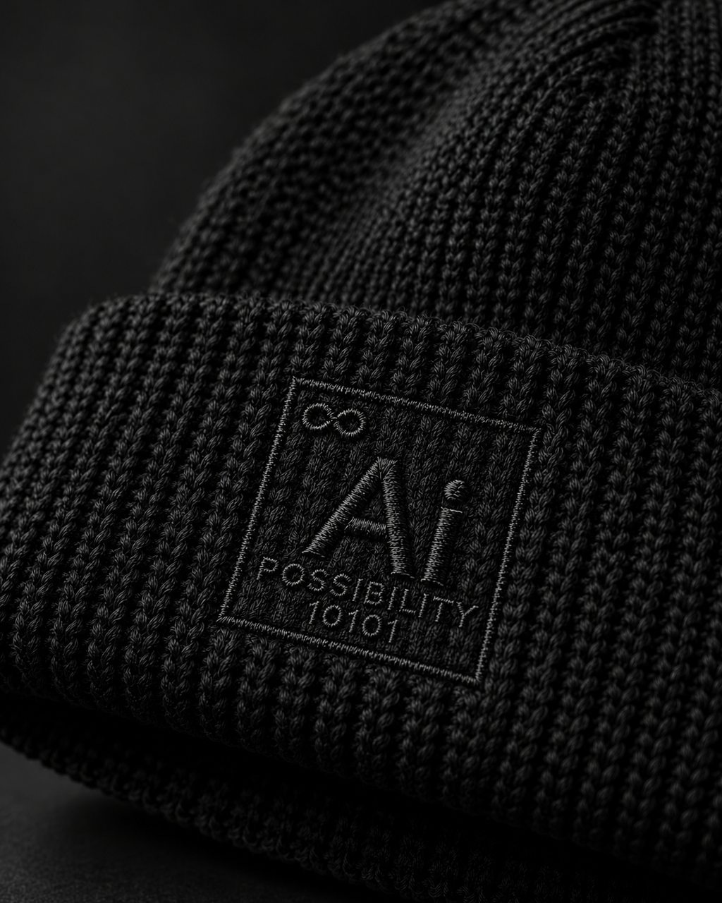 Close-up of the black Possibility Beanie cuff with the Ai + You element tile embroidered tone-on-tone directly into the rib knit